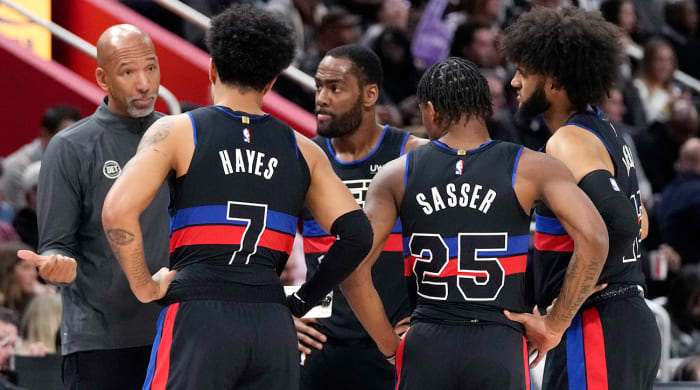 Pistons coach Monty Williams greets guard Cade Cunningham (2) and forward Isaiah Livers (12) as they come off the floor against the Pacers in the first quarter at Little Caesars Arena.